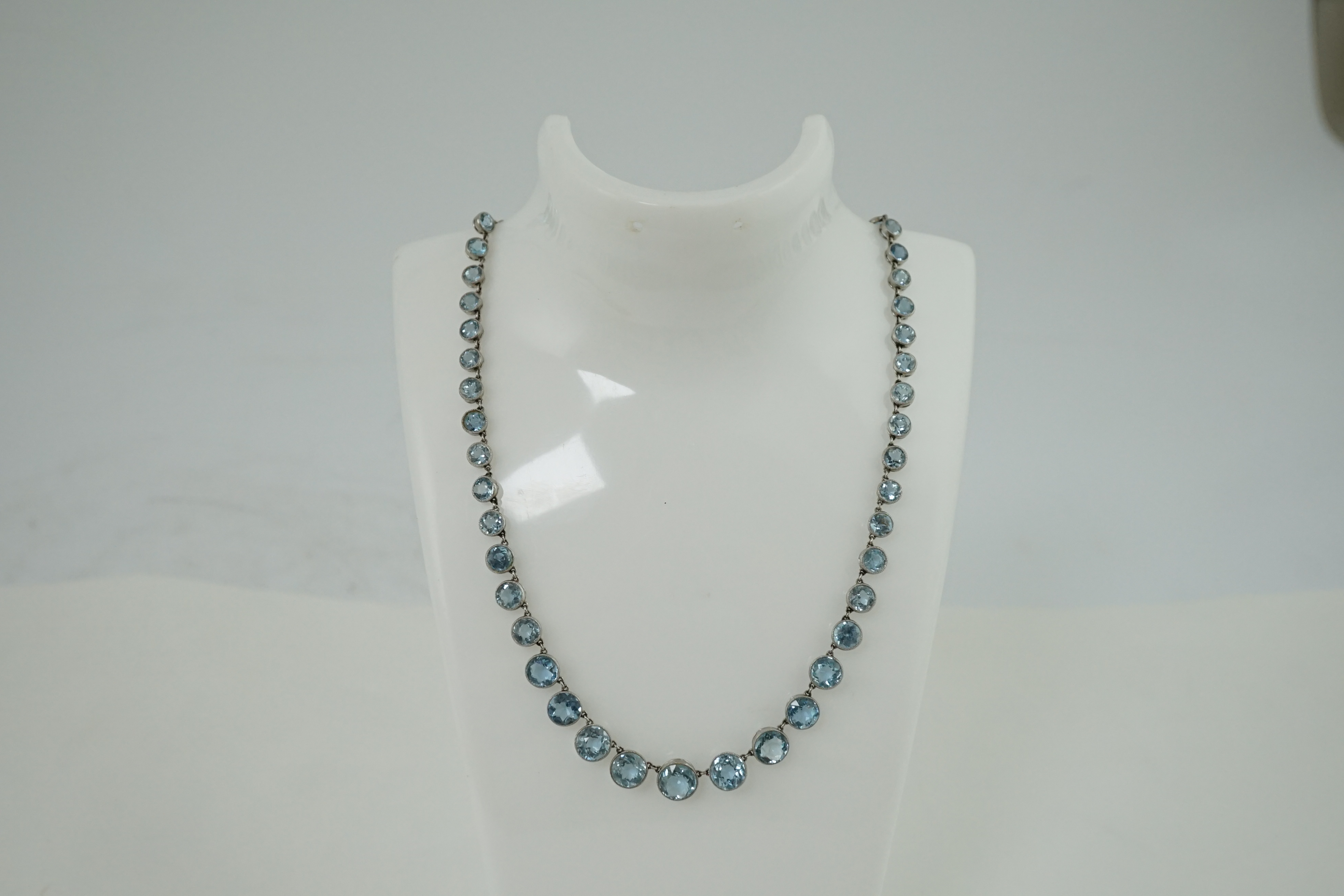 A Belle Epoque platinum and millegrain set graduated aquamarine necklace